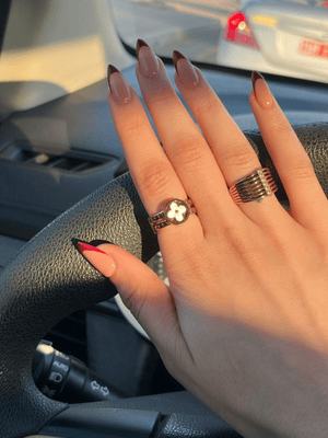 Acrylic French tip nail art with white background design captured in car by Riri Nails Oman