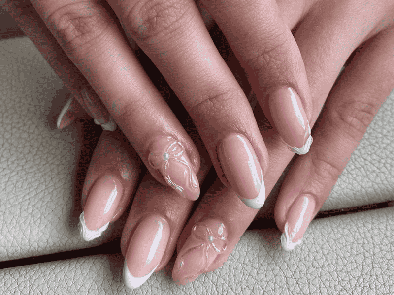 Riri Nails Oman builder Gel manicure featuring elegant French tip, wave, and bow nail art