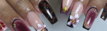 Elegant acrylic nail art with glossy finish and floral details at Riri Nails salon in Muscat, Oman.