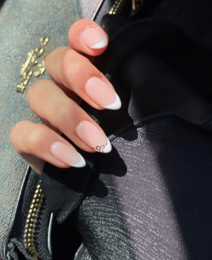 Acrylic nail extension with minimal bow nail art design by Riri Nails salon in Muscat, Oman.