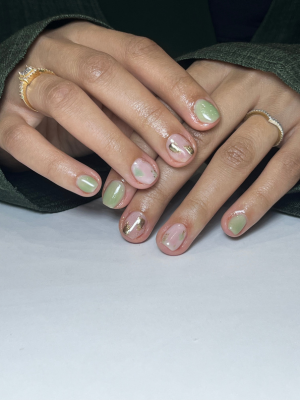 Riri Nails Oman gel on natural nail service featuring green magical sparkle nail designs